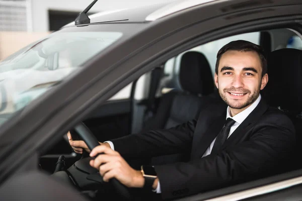 Smiling man looking from a car window — Stock Photo, Image