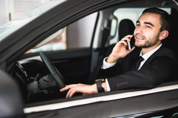 Retrato de hombre de negocios guapo usar el teléfono en el coche — Foto de Stock