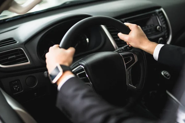 Mão de um empresário ao volante de um carro — Fotografia de Stock
