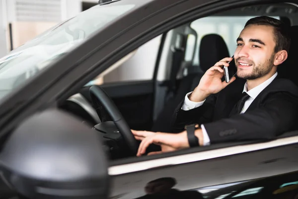 Retrato de hombre de negocios guapo usar el teléfono en el coche — Foto de Stock