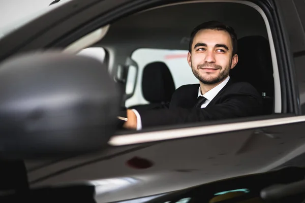 Sonriente hombre mirando desde la ventana de un coche — Foto de Stock