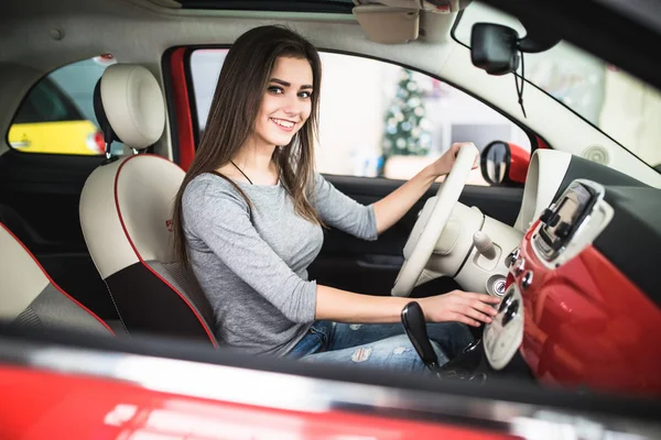 Femme conduisant une voiture neuve et moderne et tourner le bouton sur le panneau de tableau de bord dans la voiture — Photo