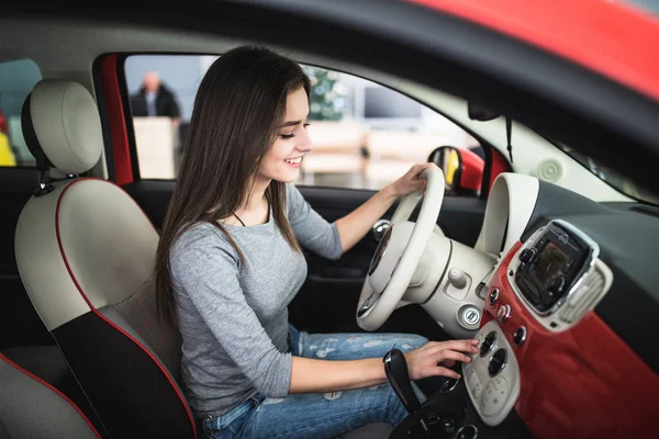Женщина за рулем нового и современного автомобиля и повернуть кнопку на панели приборной панели в автомобиле — стоковое фото