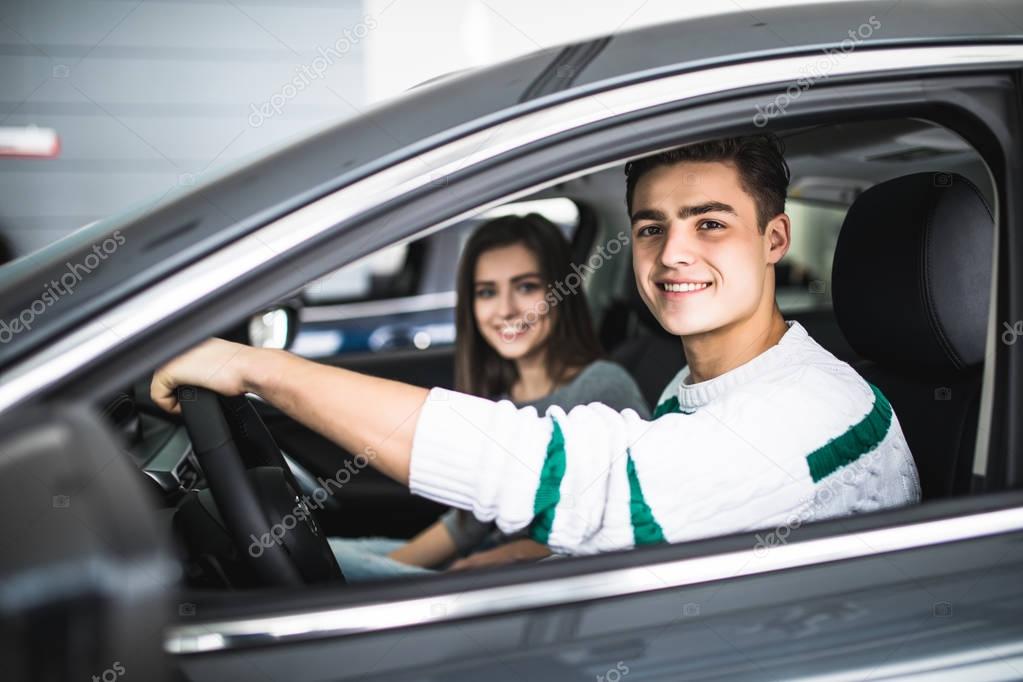 Young couple with keys to new car