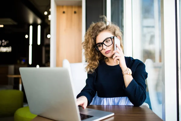 Vacker affärskvinna arbetar sittande vid sitt skrivbord på kontoret. Titta på laptop. — Stockfoto