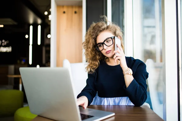 Schöne Geschäftsfrau, die an ihrem Schreibtisch im Büro sitzt. Blick auf Laptop. — Stockfoto