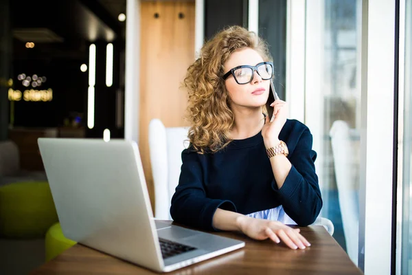Beautiful businesswoman working sitting at her desk in the office. Look in window. — Stock Photo, Image