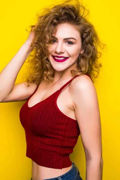 Young curly beauty woman posing on yellow background with different gesture.