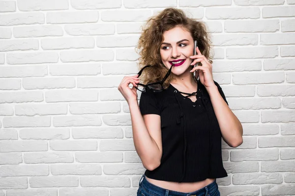 Jonge vrouw in zwarte shirt naast bakstenen muur stijlvolle fotomodel buiten — Stockfoto