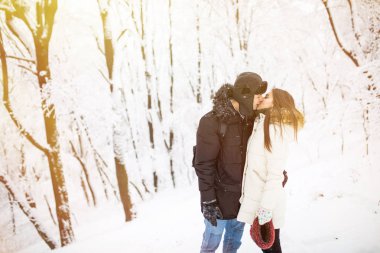 Happy young couple having fun in the winter park clipart
