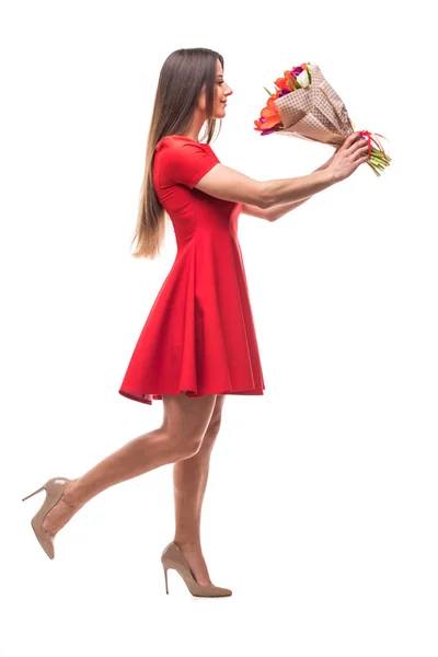 Εικόνα του χαριτωμένο γυναίκας με κόκκινο φόρεμα με μπουκέτο με τουλίπες — Φωτογραφία Αρχείου