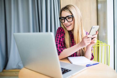 Teknoloji iş ve diğer kişilere bağlanmak için dizüstü bilgisayarını ve onun telefon kullanan kadın gülümse