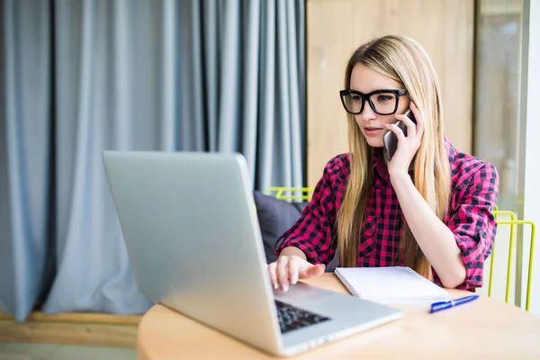 若いビジネスの女性は、オフィスでは、電話をかけ式を心配して彼女の前にあるノート パソコンを見て彼女の顔に. — ストック写真