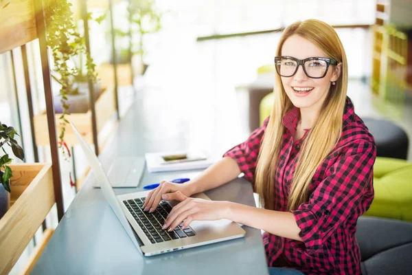 Jonge vrouwelijke ondernemer werken vergadering op een bureau te typen op haar laptopcomputer in een kantoor, bekijken van bovenaf — Stockfoto