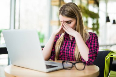 Yorgun ve stresli hissediyor. Gözleri kapalı ve ofis onun çalışma evinde otururken burun masaj tutmak sinir bozucu genç kadın