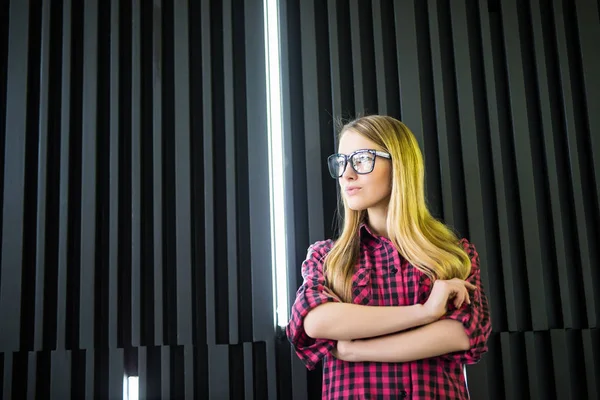 Donna in occhiali con le mani incrociate in edificio per uffici — Foto Stock