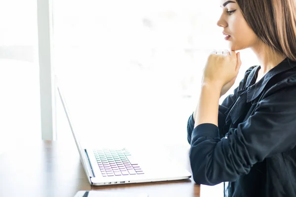 Ung flicka med sin laptop i kafé och titta på skärmen — Stockfoto