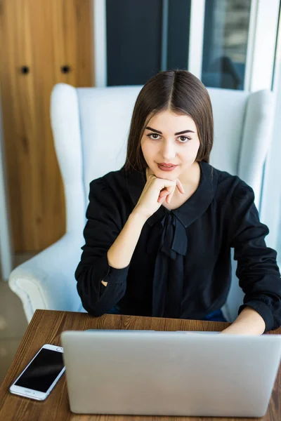 Vista superior, joven mujer de negocios sentada en el escritorio y trabajando en línea en el ordenador portátil mientras usa el teléfono inteligente. Aprendizaje del estudiante en línea . — Foto de Stock