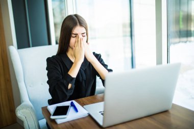 Masadaki laptop görevi tamamlamak için yol hakkında düşünme yorgun fikirli kadın