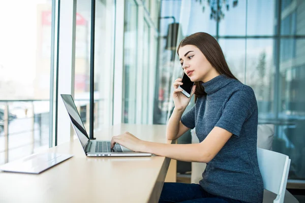 Retrato de vista lateral de una joven empresaria que tiene una llamada de negocios en la oficina. Mujer hablando por teléfono móvil . — Foto de Stock
