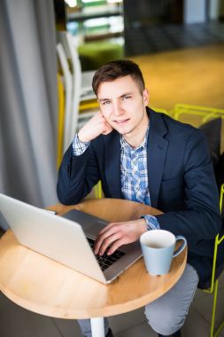 Tablet ve kalem kafede kahve görünümü yukarıdan bir fincan ile ahşap tablo ile dizüstü bilgisayar kullanarak iş adamı