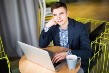 Tablet ve kalem kafede kahve görünümü yukarıdan bir fincan ile ahşap tablo ile dizüstü bilgisayar kullanarak iş adamı