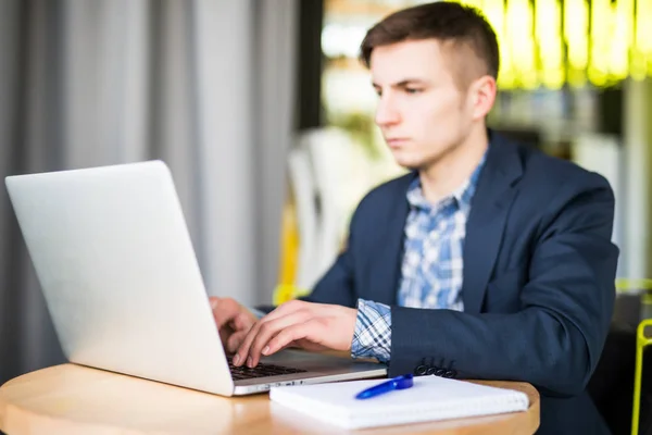 Feliz joven trabaja en su computadora portátil para hacer todos sus negocios temprano en la mañana con su taza de café — Foto de Stock