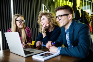 Modern kafede masada dizüstü bilgisayar kavramı kullanarak çeşitlilik arkadaşlar.