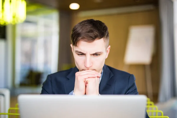 Retrato del hombre serio mirando el ordenador portátil — Foto de Stock