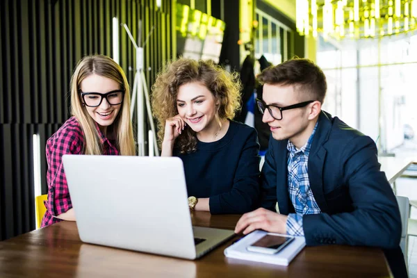 Los jóvenes en la oficina moderna sobre portátil disscusing o cepillado, navegar por Internet. Estudiante sobre portátil . — Foto de Stock