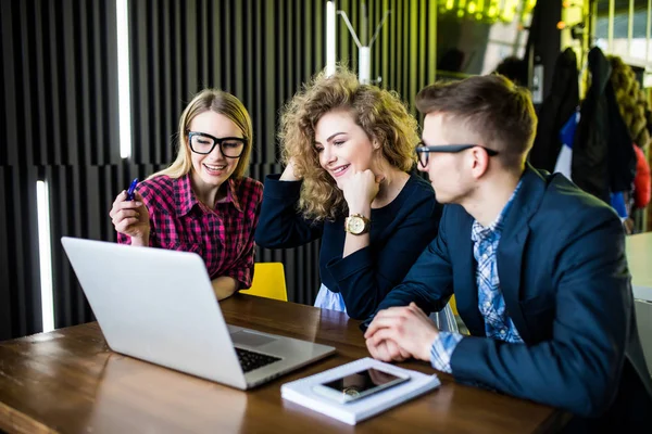 Diversiteit vrienden dankzij het concept van de laptop aan tafel in de moderne café. — Stockfoto