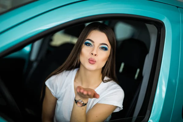 Jong meisje was het besturen van de auto. Vrouw stuurt een lucht-kus. — Stockfoto