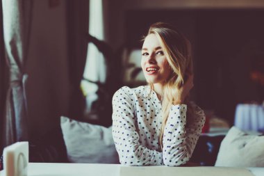 Kafede ışıklar arka plan üzerinde oturan güzel sarışın kız.