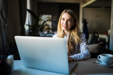 Dizüstü bilgisayar kullanan genç kadın. Açık bir kafede dizüstü bilgisayar üzerinde çalışan erkek.