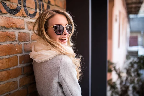 Mujer inspirada al aire libre en el sol brillante primavera, disfrutar de su vida cerca de la pared de ladrillo —  Fotos de Stock