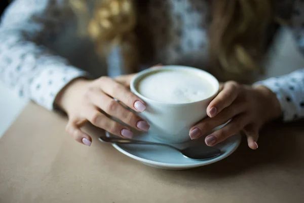 Zamknij się obraz kobiety ręce się trzęsą cappuccino w kawiarni. — Zdjęcie stockowe