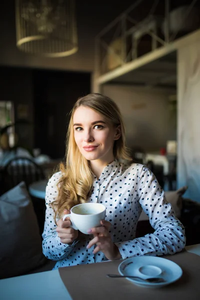 Mujer rubia joven disfrutando de la hora del café en la cafetería —  Fotos de Stock