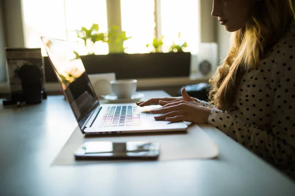 Bijgesneden shot van een vrouw in café werken op haar laptopcomputer. — Stockfoto