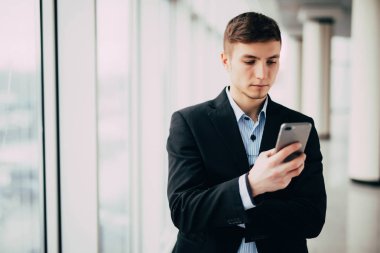 Akıllı telefon kullanma office bir genç çekici iş adamı görünümünü
