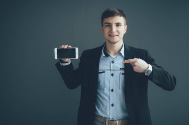 Boş smartphone ekranında siyah arka plan üzerinde mutlu işadamı işaret parmağı