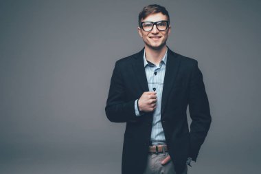 Gri arka planda duran havalı iş adamı