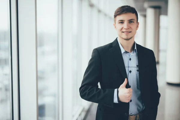 Молодий бізнесмен йде великим пальцем вгору в офісі — стокове фото