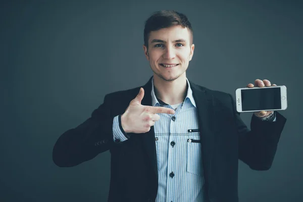 Feliz hombre de negocios señalando el dedo en la pantalla del teléfono inteligente en blanco sobre fondo negro — Foto de Stock