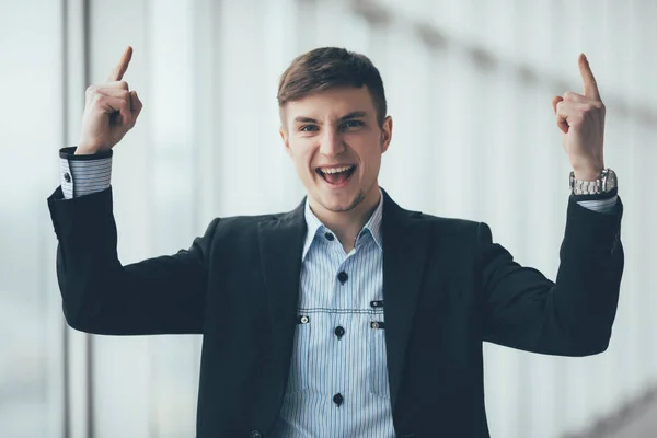 Ofisinde parmak işaret bir genç iş adamı portresi — Stok fotoğraf
