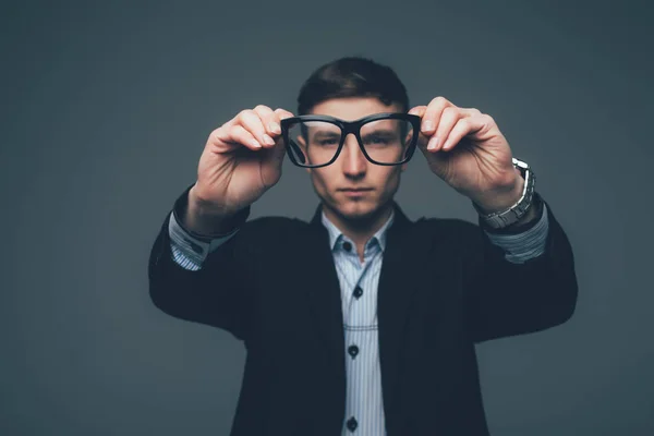 Homem de negócios está olhando através dos óculos em cinza — Fotografia de Stock
