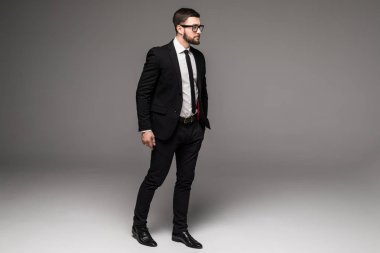 Tam boy gri izole kendine güvenen genç işadamlarının duran güneş gözlüğü