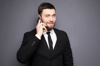 Zarif işadamı bir akıllı telefon karanlık bir arka plan üzerinde ciddi sohbet