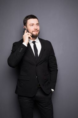 Zarif işadamı bir akıllı telefon karanlık bir arka plan üzerinde ciddi sohbet
