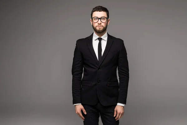 Handsome young bearded businessman in classic suit and looking away, on a gray background — Stock Photo, Image