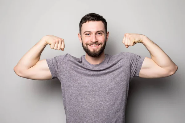 Jeans gömlek gri bir arka plan üzerinde kabartmalı genç adam kasları — Stok fotoğraf